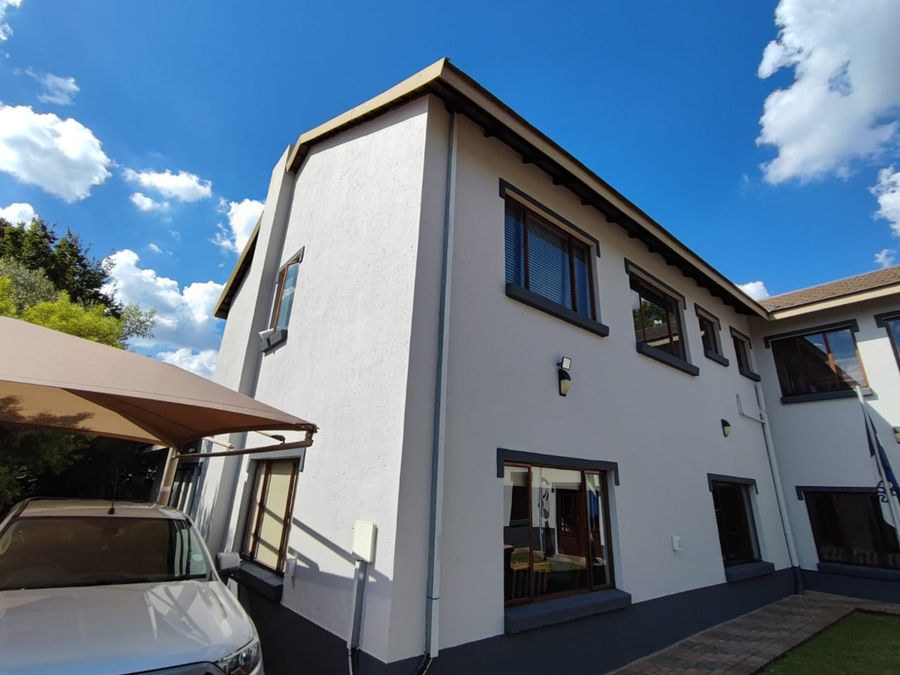 A white double-storey house under a blue sky