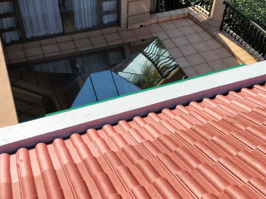 A tiled roof and parapet above a courtyard skylight