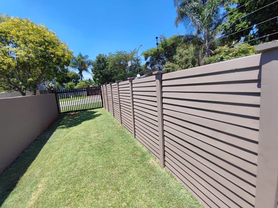 A long painted boundary wall beside a lawn