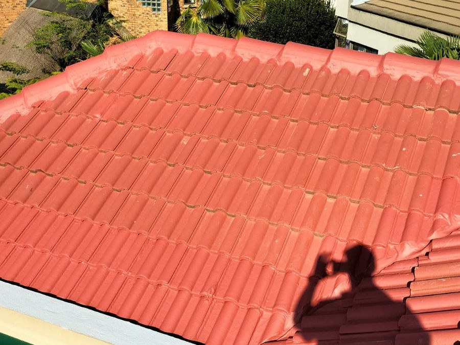 A red tiled roof, the photographer's shadow on the tiles