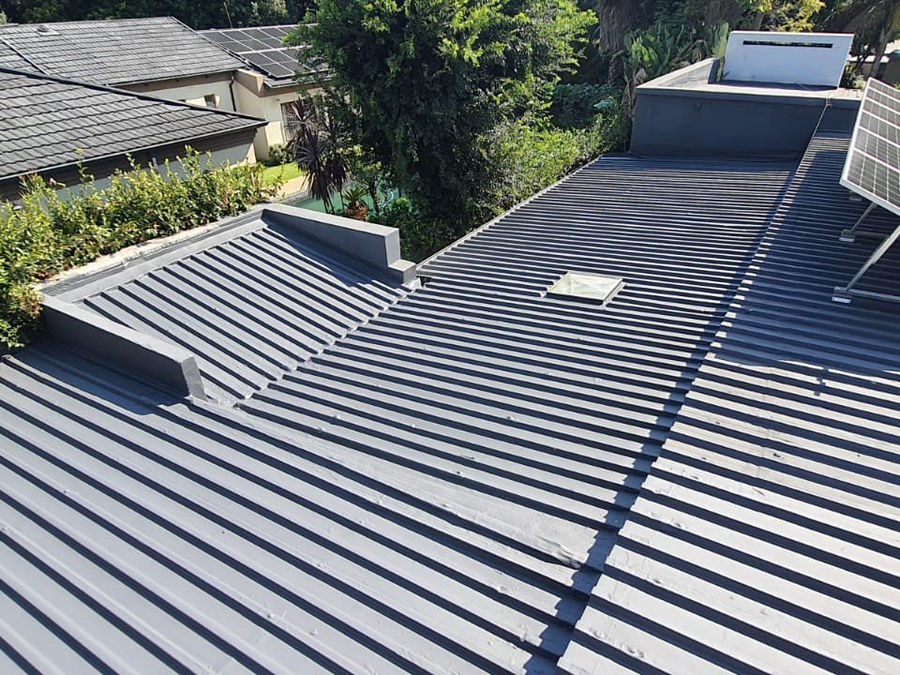 A grey steel roof with parapets and a box gutter